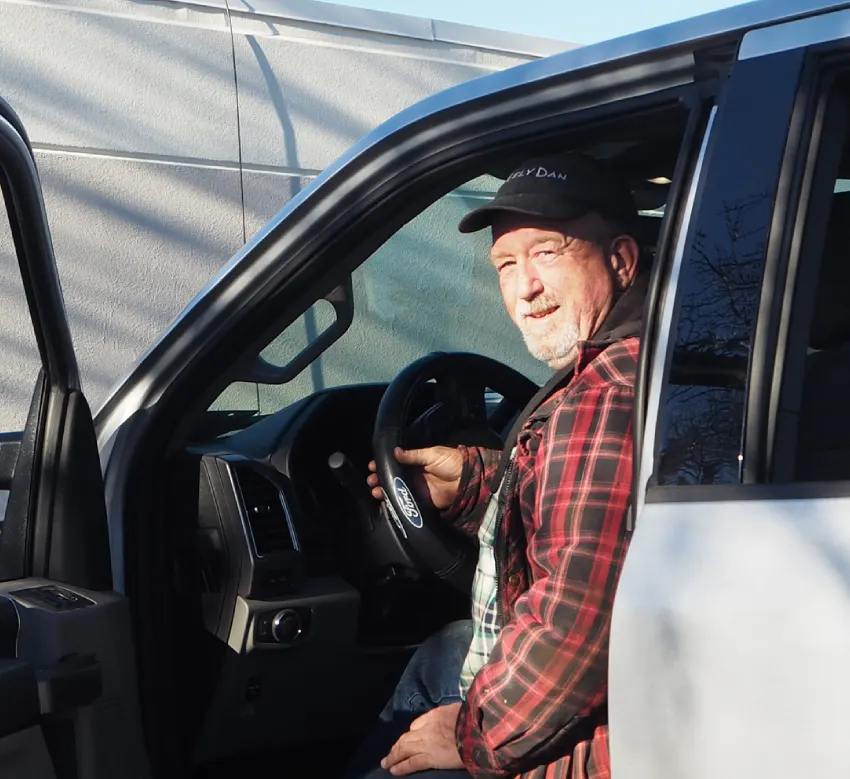 A man sitting in the drivers seat of his truck.